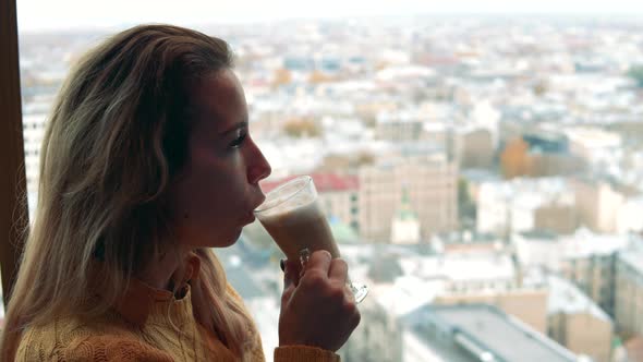 Urban View with a Woman Drinking Coffee Next To It