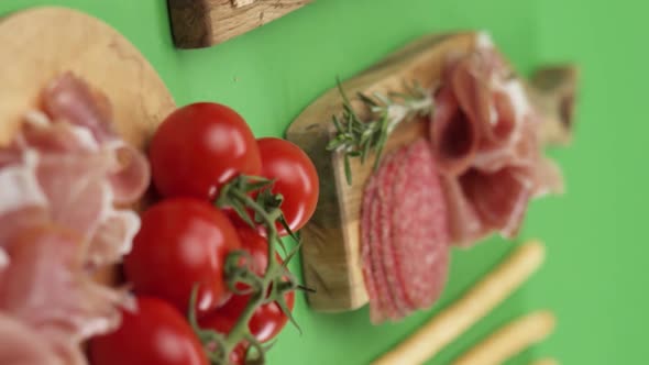 Vertical video, Close-up: cold cuts, salami, prosciutto, jamon, cherry tomatoes, sliced ​​sausage