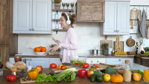 Beautiful Pregnant Woman Dancing In Headphones In Kitchen