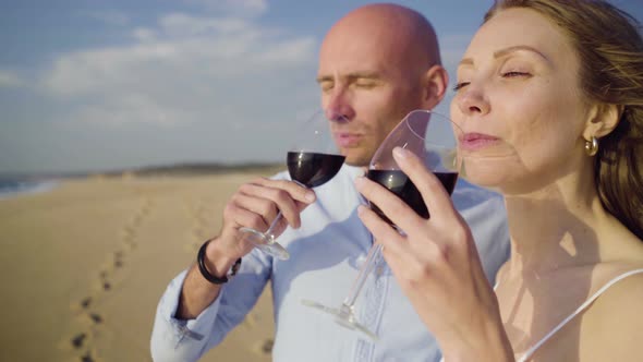 Couple Drinking Wine and Kissing on Beach