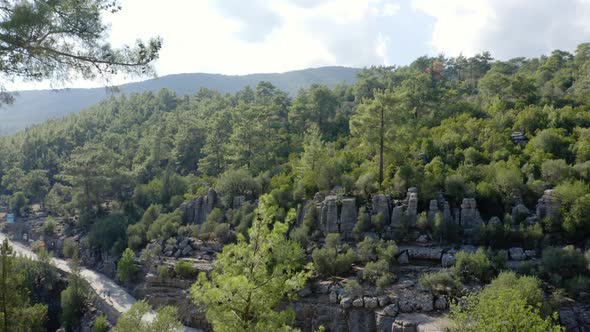 Panoramic Aerial View of Mountains Green Forests Road and Rocky Formations on a Summer Day