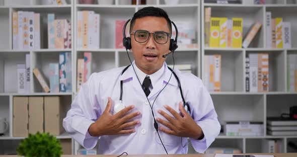 Doctor with headset making conference call and looking at camera