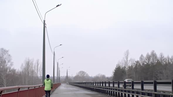 Man Jogging on Bridge in Dull Weather