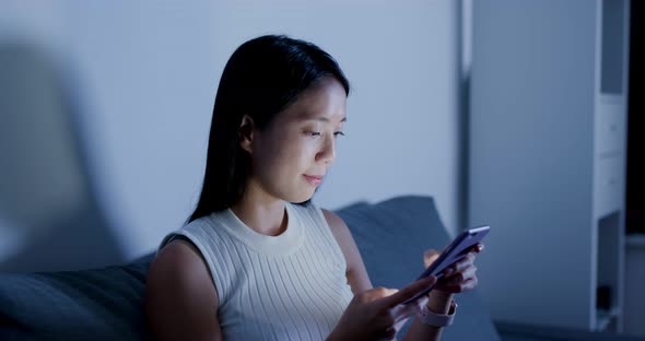 Woman Search on Smart Phone and Sit on Sofa at Home