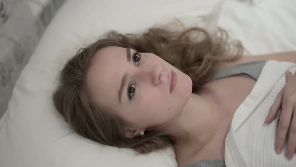 Pensive Beautiful Young Woman Thinking in Bed