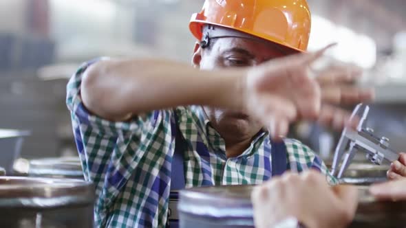 Factory Worker Using Caliper