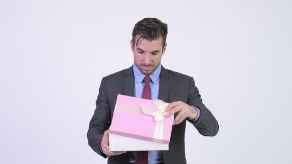 Young Happy Hispanic Businessman Opening Gift Box