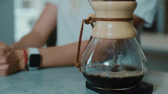 Barista making the aroma of  Filter coffee for female costumer.