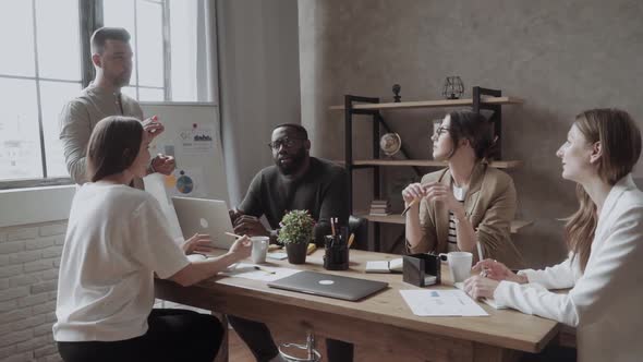 Group of Casually Dressed Businesspeople Discussing Ideas in the Office