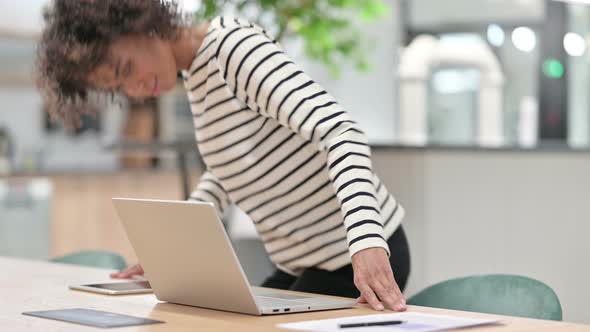 Young African Woman Coming and Starting Work on Laptop