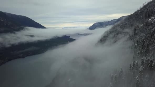 Wide aerial shot of a valley covered by winter fog in Vancouver Island, Canada