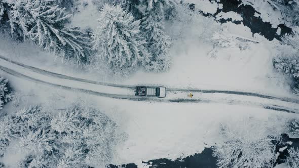 Winter Aerial Footage of a Curved Windy Road Village Cutting Through Mountains Landscape