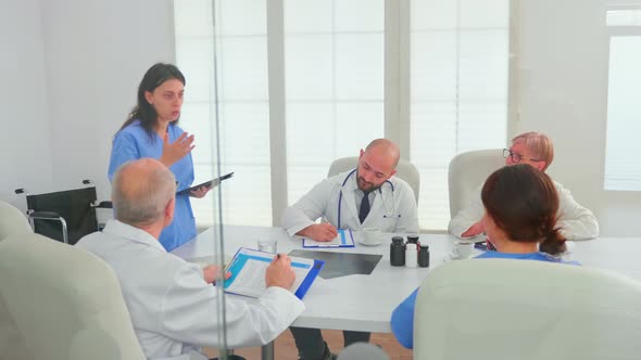 Young Medical Nurse Using Tablet Explaining Disease Development