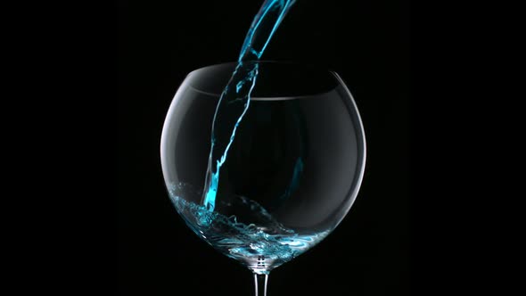 Pouring blue water into glass, Slow Motion