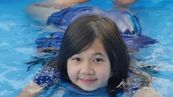 Cute Asian Girl Swimming And Playing In A Pool Slow Motion