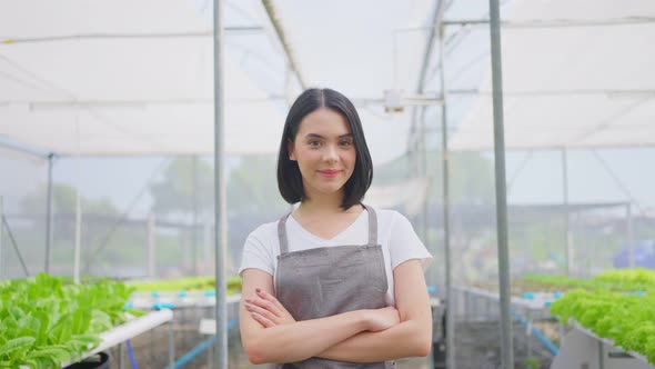 Asian woman farmer owner working in vegetables hydroponic farm with happiness and look at camera.