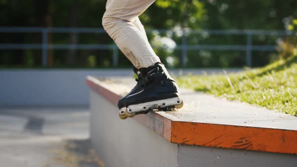 Aggressive Inline Roller Skater Doing Tricks in Concrete Skatepark Outdoors with Beautiful