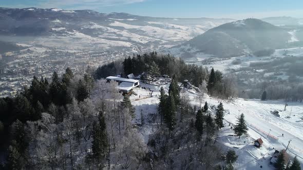 Aerial view of ski slope and skiers skiing down the slope in beautiful ski resort.