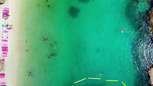 Overhead view dolly in of people inside Mambo Beach on a sunny day, Curacao, Dutch Caribbean island