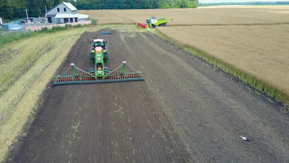 Plow Attached To A Tractor On A Field. Modern farming tractor which plowing agriculturafield