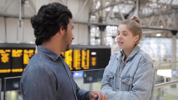 Two friends talking inside of a train station