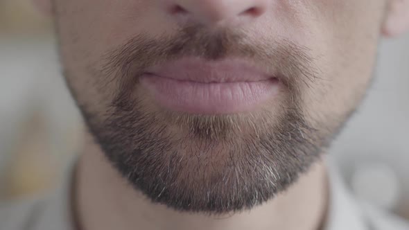 Lower Jaw of an Adult Sad Bearded Man Trying To Smile with a Forced Smile. Negative