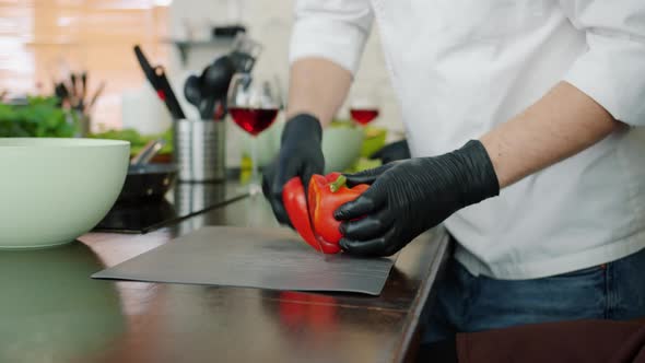 Close-up of Male Hands in Gloves Chopping Pepper Cooking Salad in Kitchen