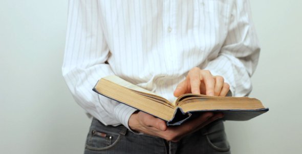 Man Reading a Book in Hands