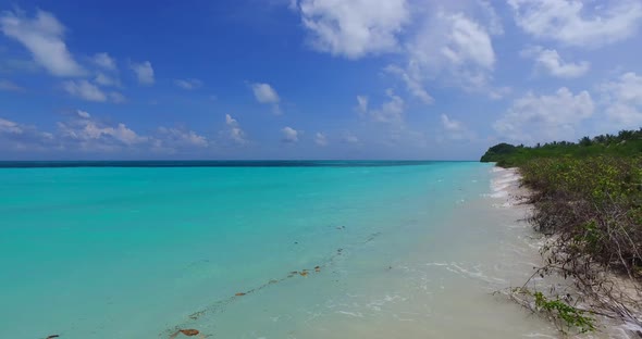 Wide birds eye clean view of a paradise sunny white sand beach and blue ocean background in colourfu