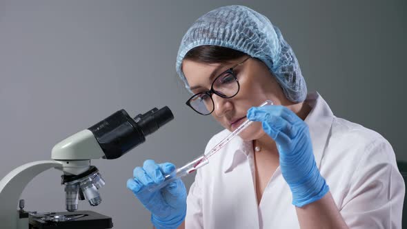 Woman Assistant Mixes Blood and Transparent Liquid in Tube