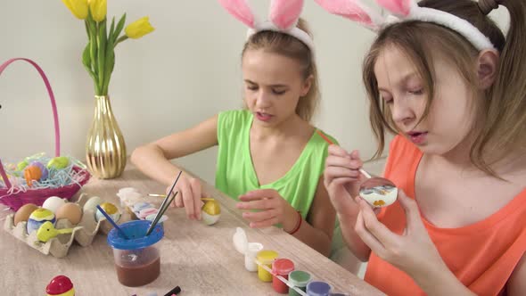Girls Decorate Easter Eggs with Paint