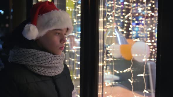 Boy in Santas Hat Looking in Shop Window