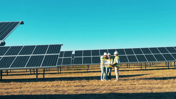 Group of Engineers Are Observing the Photovoltaic Power Field at a Power Plant, Solar Energy Concept