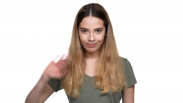 Portrait of Hospitable Woman with Dyed Auburn Hair Smiling on Camera and Greeting with Waving Hand