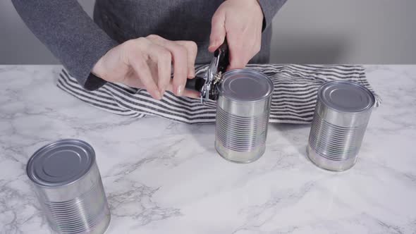 Opening canned white beans with can opener.