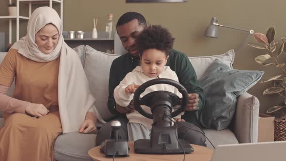 African American Muslim Father and Little Son Playing Games on Laptop