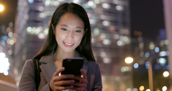 Business woman use of cellphone city city at night