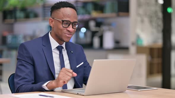 Cheerful African Businessman Doing Video Call on Laptop in Office