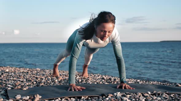 Fitness Woman Performing Push Ups on Pebble Beach Enjoying Morning Outdoor Training Slow Motion