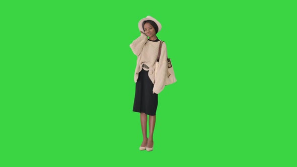 Fashionable African American Woman Posing in Knitwear and White Hat on a Green Screen, Chroma Key