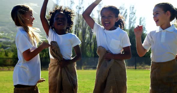 Children playing a sack race in park