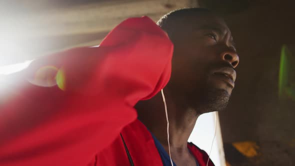 Focused african american man putting earphones on before exercising outdoors