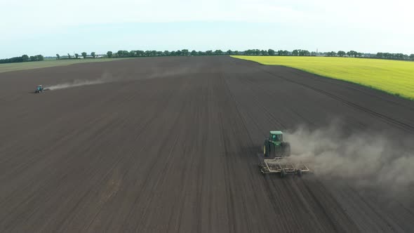 Aerial View of Tractors Harrowing Field for Sowing