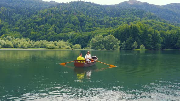 Young Couple are Sailing on a Old Wooden Boat in Biogradsko Lake in Montenegro