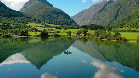 Woman on the Boat Catches a Fish on Spinning in Norway