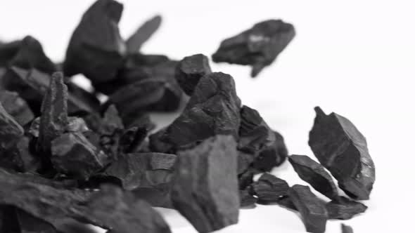 Super Slow Motion Shot of Coal Falling on White Background at 1000 Fps.