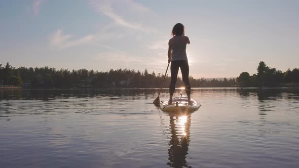 Adventurous Caucasian Adult Woman Paddling on a Stand Up Paddle Board