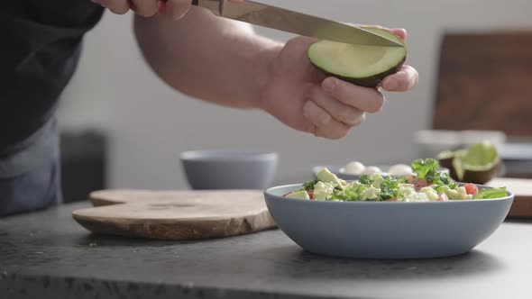 Slow Motion Man Make Salad with Kale Mozzarella Avocado and Cherry Tomatoes Cut Avocado