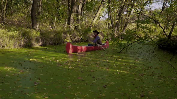 Cowboy in a Canoe Floats on the River
