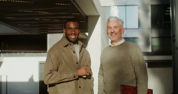 Two Men of Different Nationalities are Smiling Looking at the Camera